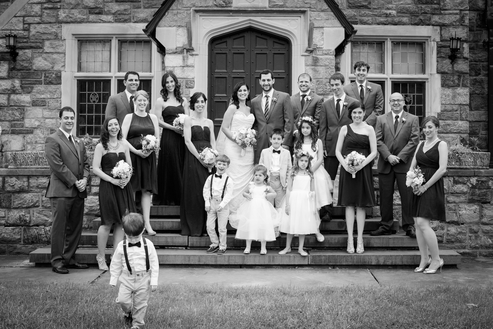black and white wedding party photo little boy running out of frame